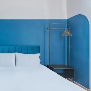 罗马Hotel Infinito - Gruppo BLAM HOTELS的蓝色的卧室,配有床和蓝色的墙壁