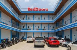 巨港RedDoorz Plus near Palembang Icon Mall 2的停车场内停放汽车的大型建筑