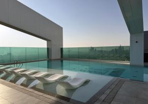 迪拜Dubai Frame view, 5 mins to Burj Khalifa的一座带白色椅子的游泳池的建筑
