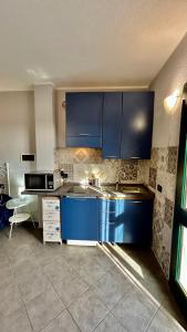里瓦利古雷阿苏拉布瑞齐纳农家乐的厨房配有蓝色橱柜和水槽