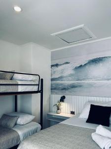 圣地亚哥Yogi hostel boutique的一间卧室设有两张双层床,并装饰有海洋画