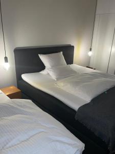 埃尔克伦茨林登霍夫酒店的一间卧室配有两张带白色床单的床