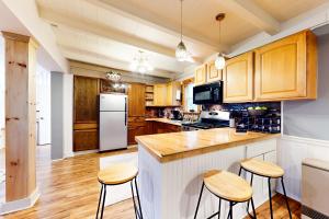 温莎Summit House的厨房配有木制橱柜和白色冰箱。