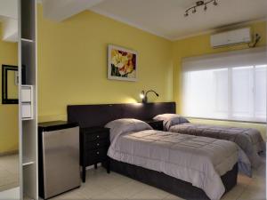 内乌肯Posada Relmú的黄色墙壁客房的两张床