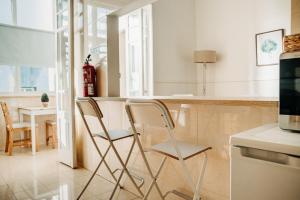 里斯本Belém Tejo - Jardim的厨房在柜台前配有两把椅子