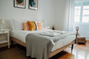里斯本Belém Tejo - Jardim的一间卧室配有一张床铺,床上有毯子