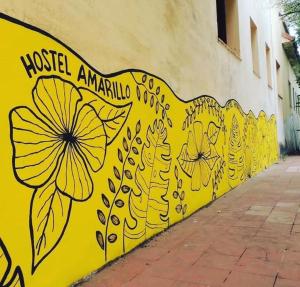 San IgnacioHostel Amarillo的黄色的墙壁,上面画着鲜花