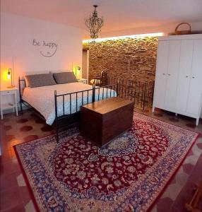 奥尔塔圣朱利奥Casa Longhi的一间卧室配有一张床和一张桌子的地毯