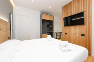 西尔米奥奈莫罗酒店的卧室配有白色的床和平面电视。