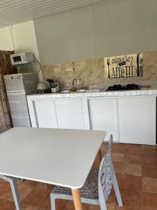 MatouryCasa DeLyZy的厨房配有白色橱柜和白色桌子