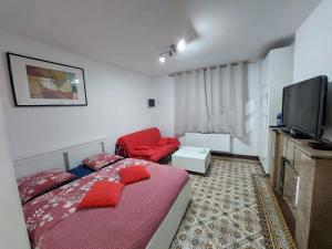 沙勒罗瓦Maison LYDIE - Meublé de vacances 3 étoiles的一间小卧室,配有一张床和一把红色椅子