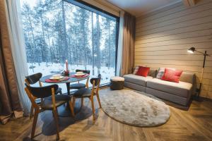 罗瓦涅米Invisible Forest Lodge的客厅配有桌子、沙发和窗户