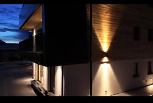 安达洛Chalet Larix Andalo Deluxe Apartments的建筑的侧面有光