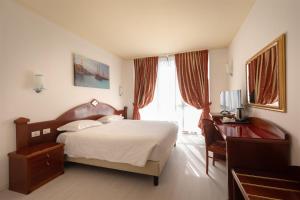 皮亚韦河畔诺文塔若文塔酒店的一间卧室配有一张床、一张书桌和一个窗户。