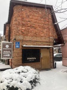 哈尔科夫Міні-готель Тремпель的积雪中带门的砖砌建筑