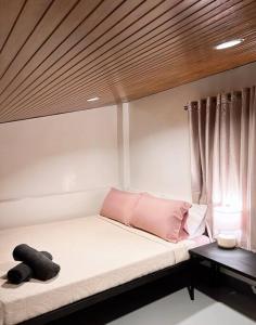 公主港Cozy Loft Near the Airport & Beach-Unit I的窗户客房内的一张带粉红色枕头的床