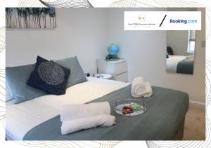 WalklyNorthfield Luxury Apartment的一张带毛巾和一盘食物的床