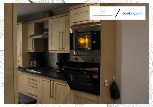 WalklyNorthfield Luxury Apartment的厨房配有木制橱柜和炉灶烤箱。
