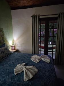 伦索伊斯Canto Verde Pousada的窗户间床上的两条毛巾