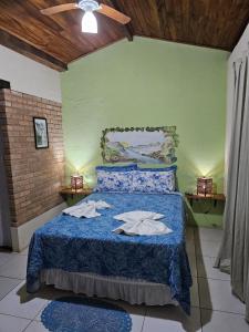 伦索伊斯Canto Verde Pousada的一间卧室配有蓝色的床和毛巾