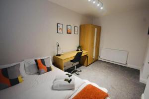 考文垂Remarkable 3-Bed Ground Floor Apartment - Coventry的一间卧室配有书桌、一张床和一张书桌