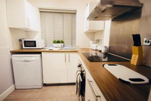 考文垂Remarkable 3-Bed Ground Floor Apartment - Coventry的厨房配有白色橱柜和炉灶烤箱。