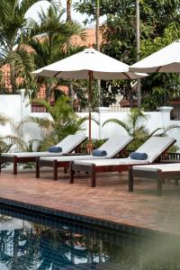 琅勃拉邦Chic stay HANA Boutique hotel的游泳池旁一排带遮阳伞的躺椅