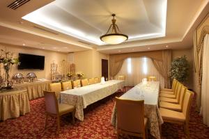巴拿马城TOSCANA INN HOTEL的一间会议室,内配两张桌子和椅子以及电视