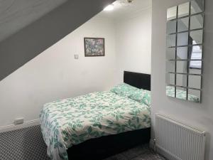 桑德兰Apartments Azalea Terrace的一间卧室配有一张带绿色和白色棉被的床