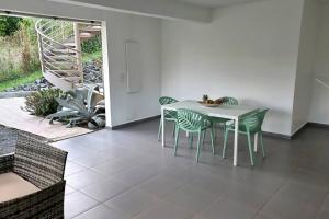 拉芒坦Appartement Pyé koko的一间配备有白色桌椅的用餐室