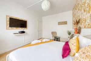 塞纳河畔皮埃尔菲特Studio cosy en centre-ville Proche de Paris的卧室配有一张带彩色枕头的大型白色床。
