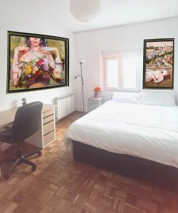 马德里安静双人房的卧室配有一张床和一张书桌,墙上挂有绘画作品