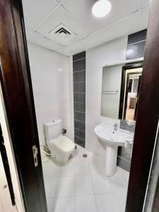 迪拜Peaceful Partition Room Near Mall of the Emirates的白色的浴室设有卫生间和水槽。