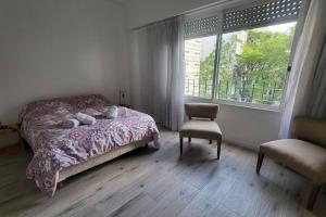 布宜诺斯艾利斯Departamento en glamourosa calle, 1 dormitorio的卧室配有床、椅子和窗户。