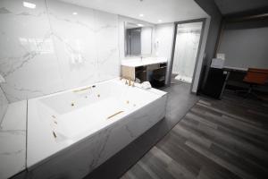 惠蒂尔惠蒂尔旅程住宿酒店的白色的浴室设有浴缸和水槽。