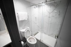 惠蒂尔惠蒂尔旅程住宿酒店的一间带卫生间和玻璃淋浴间的浴室