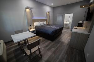 惠蒂尔惠蒂尔旅程住宿酒店的一间卧室配有一张床、一张桌子和一面镜子