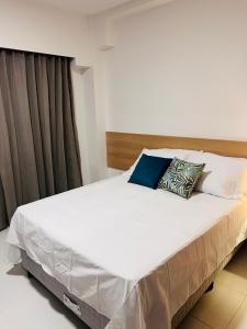 伊波茹卡Makia Beach Experience的卧室配有一张带两个枕头的大白色床