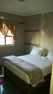 约翰内斯堡莱加西旅馆的卧室内的一张大床,设有窗户