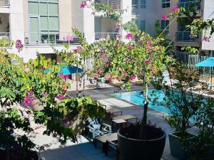 洛杉矶The Clouds的庭院设有游泳池,种有树木和鲜花
