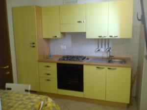 PierisCasa Vacanza Holiday的厨房配有黄色橱柜和水槽