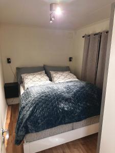 特罗姆瑟Cozy 2-Bed Apartment on the top of Tromsø!的一间卧室配有一张带蓝色棉被的床