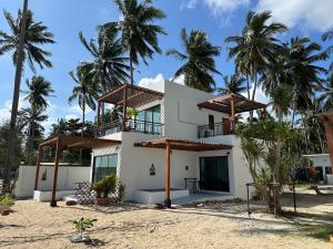 Tha SalaChansi Beachresort的棕榈树海滩上的房子