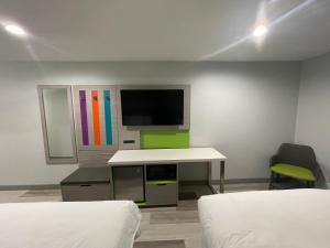 安纳海姆Travel Inn Motel的客房设有两张床、一张桌子和一台电视机。