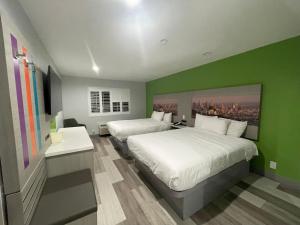 安纳海姆Travel Inn Motel的一间卧室设有两张床和绿色的墙壁