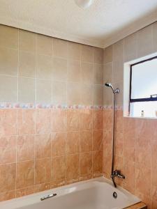 马塞卢Mphatlalatsane BnB的带浴缸的浴室和窗户。