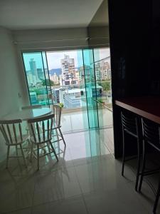 伊塔佩马Apartamento 01的配有大窗户的客房内的桌椅