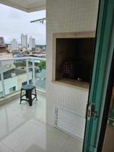 伊塔佩马Apartamento 01的阳台的门上设有景观和凳子