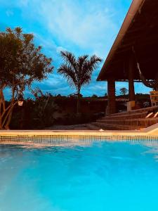 巴里查拉Casa Castañeto Barichara的一个带棕榈树和凉亭的蓝色游泳池