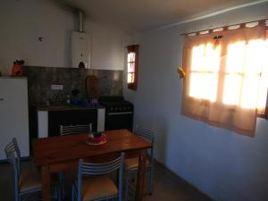 维拉帕尔克西基曼Cabaña Siquiman的厨房配有木桌、椅子和窗户。